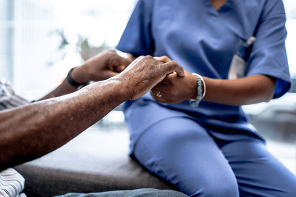 Patient care attendant assisting a patient at home